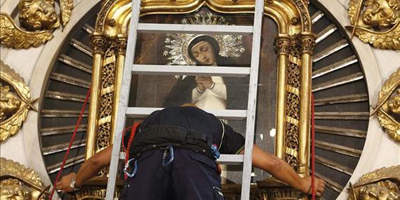 Los bomberos cumplen con la tradición de bajar el cuadro de La Paloma