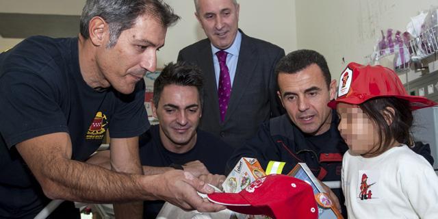 Los bomberos de la Comunidad reparten regalos a los niños ingresados en el Marañón
