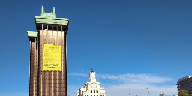 Escaladores de Greenpeace cuelgan una pancarta para denunciar la inacción política