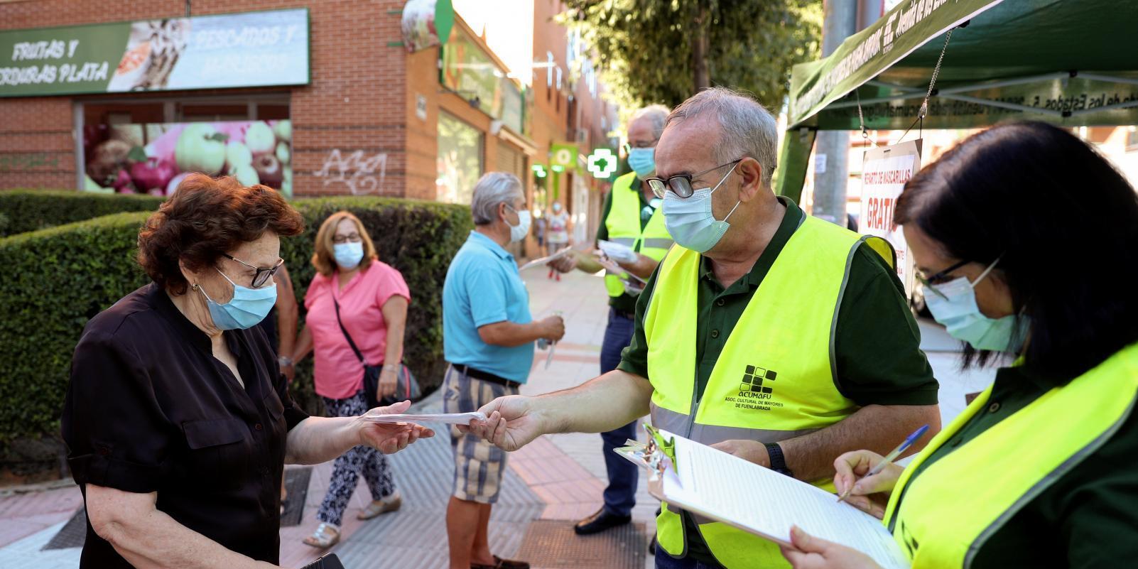 Los mayores de Fuenlabrada reparten mascarillas gratis en el mercadillo