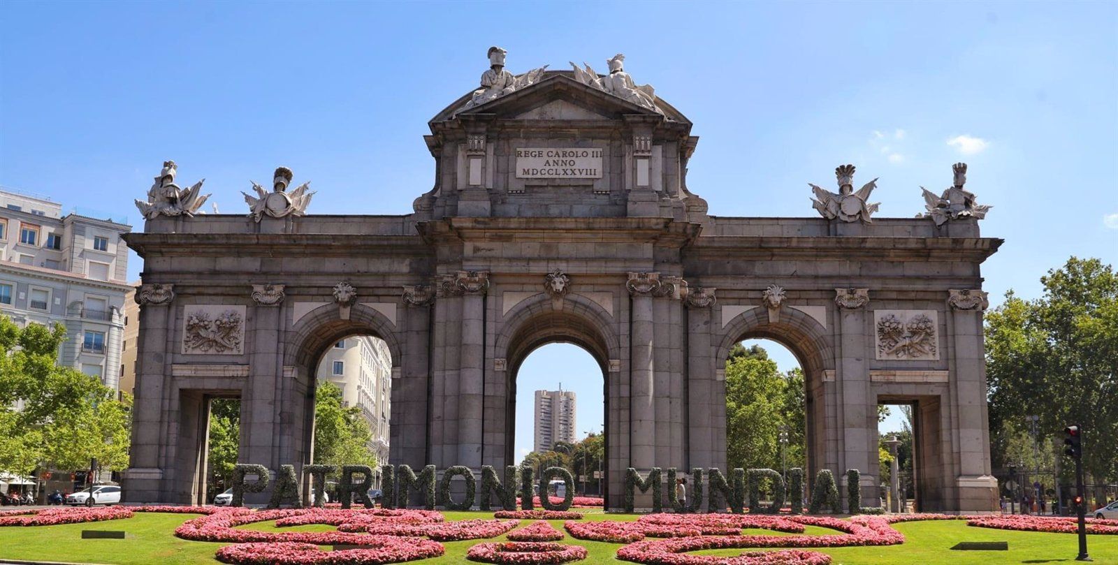 Unas letras gigantes forman las palabras Patrimonio Mundial en la Puerta de Alcalá tras la declaración de la Unesco