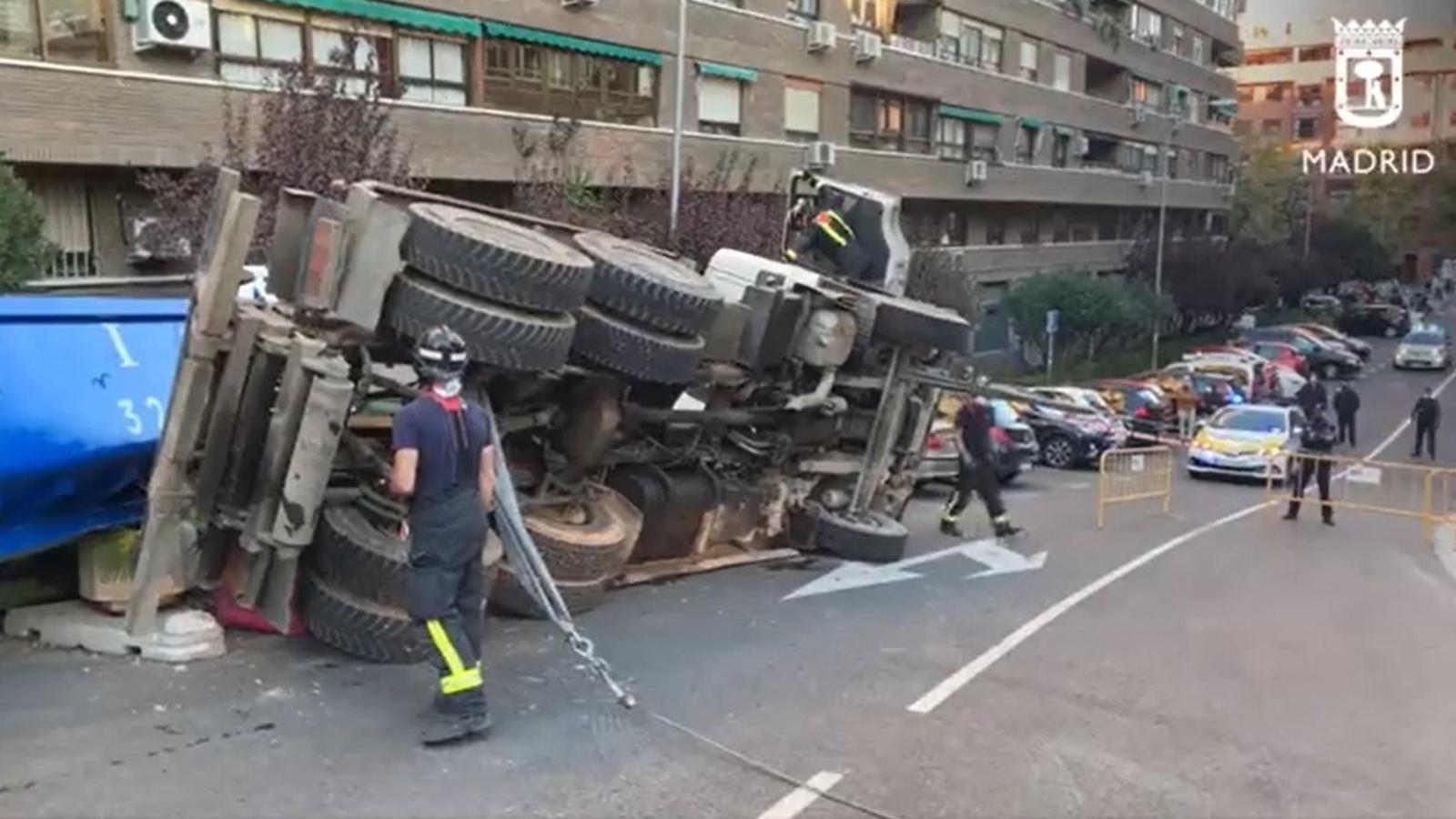 El vuelco de un camión contenedor de escombros obliga a cortar el tráfico en la calle Melilla de Arganzuela
