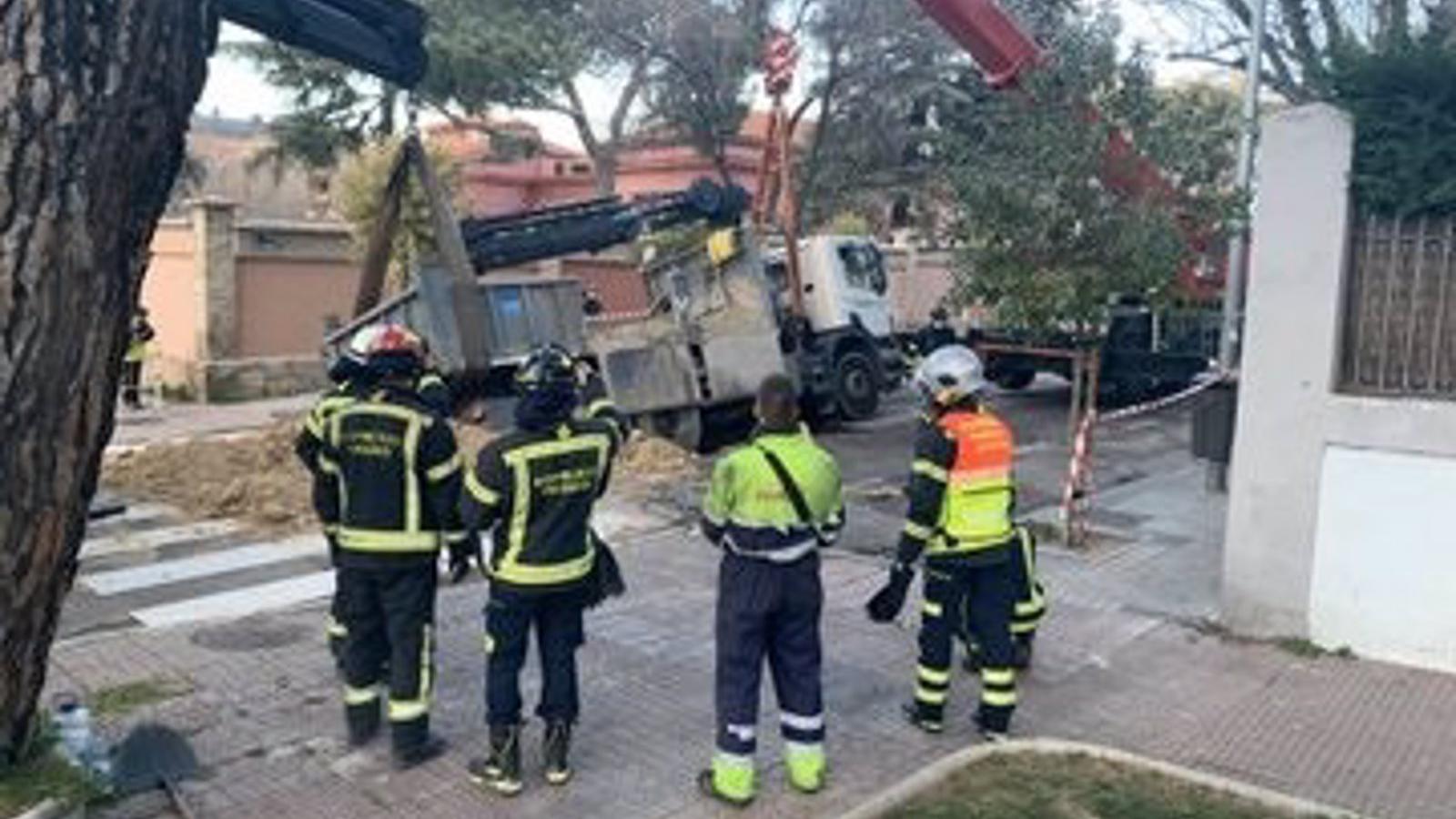 Los Bomberos de Madrid liberan un camión cargado de arena que se había hundido en el pavimento en Hortaleza