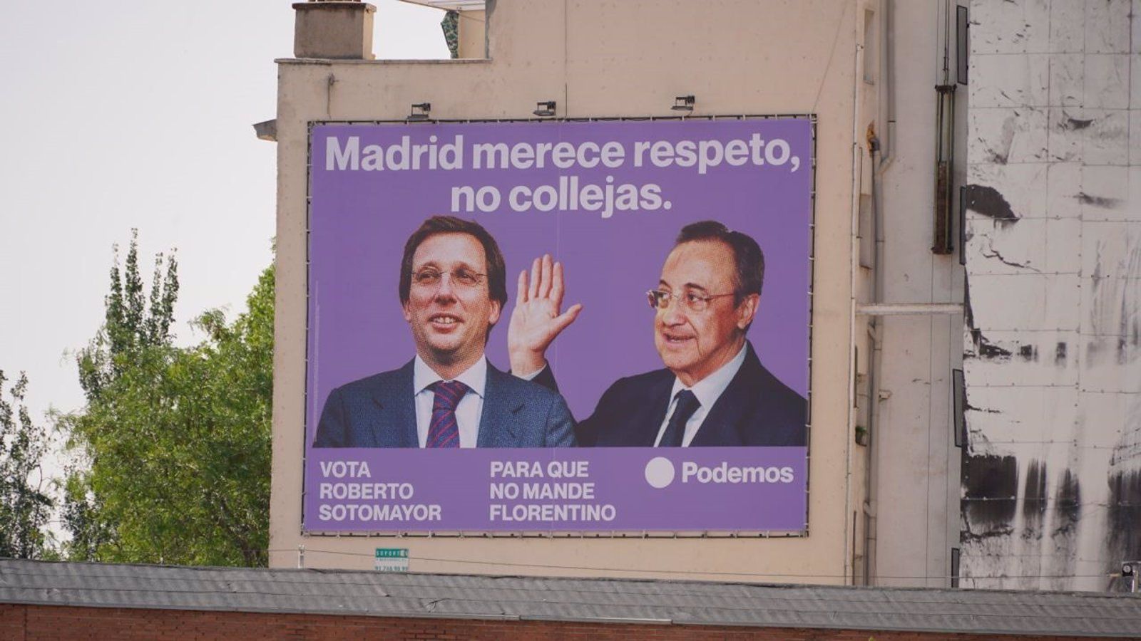 Podemos coloca una lona en Ventas con la imagen de Florentino Pérez pegando una colleja a Martínez-Almeida