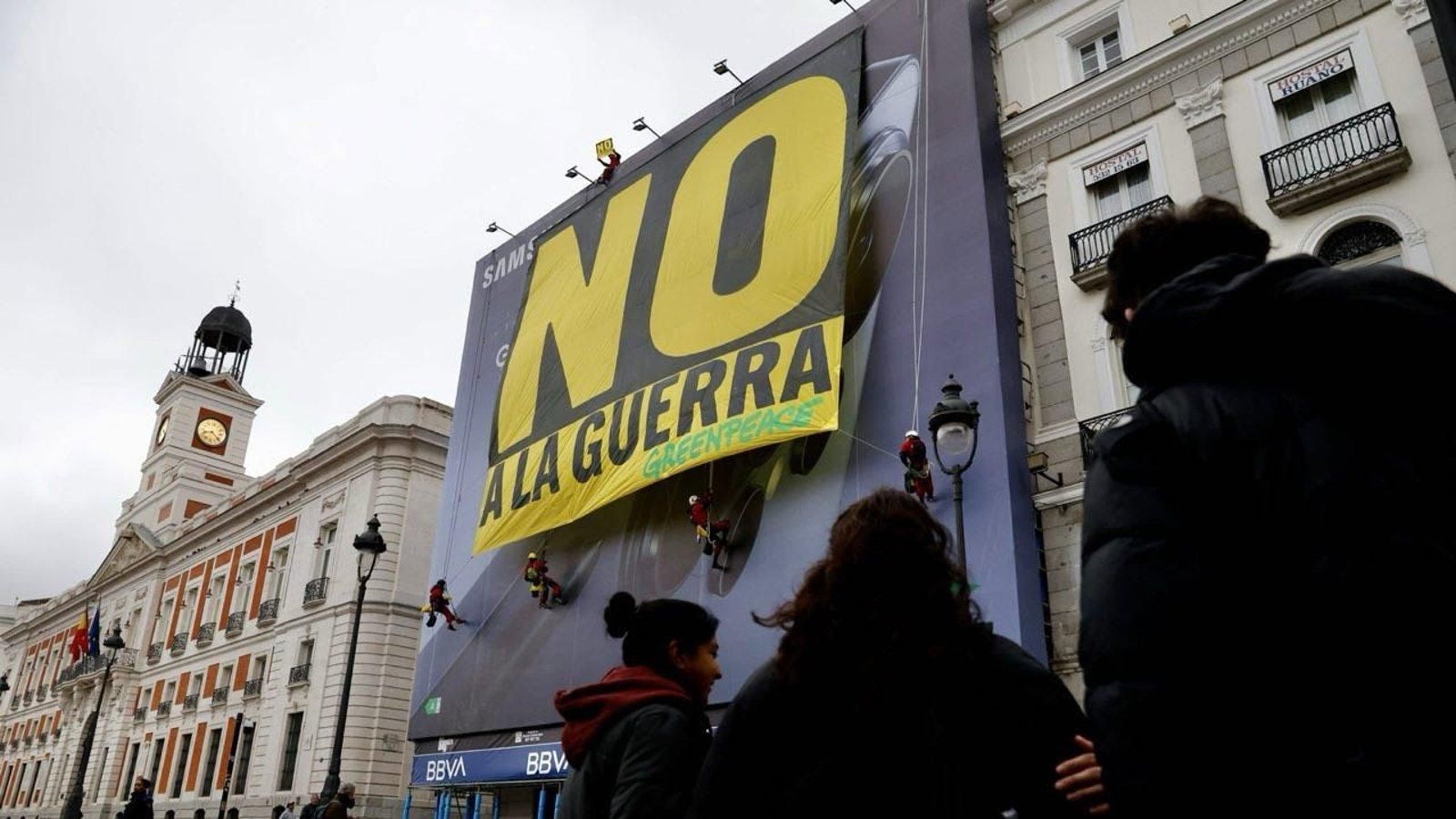 Activistas despliegan una pancarta contra la guerra en la Puerta del Sol