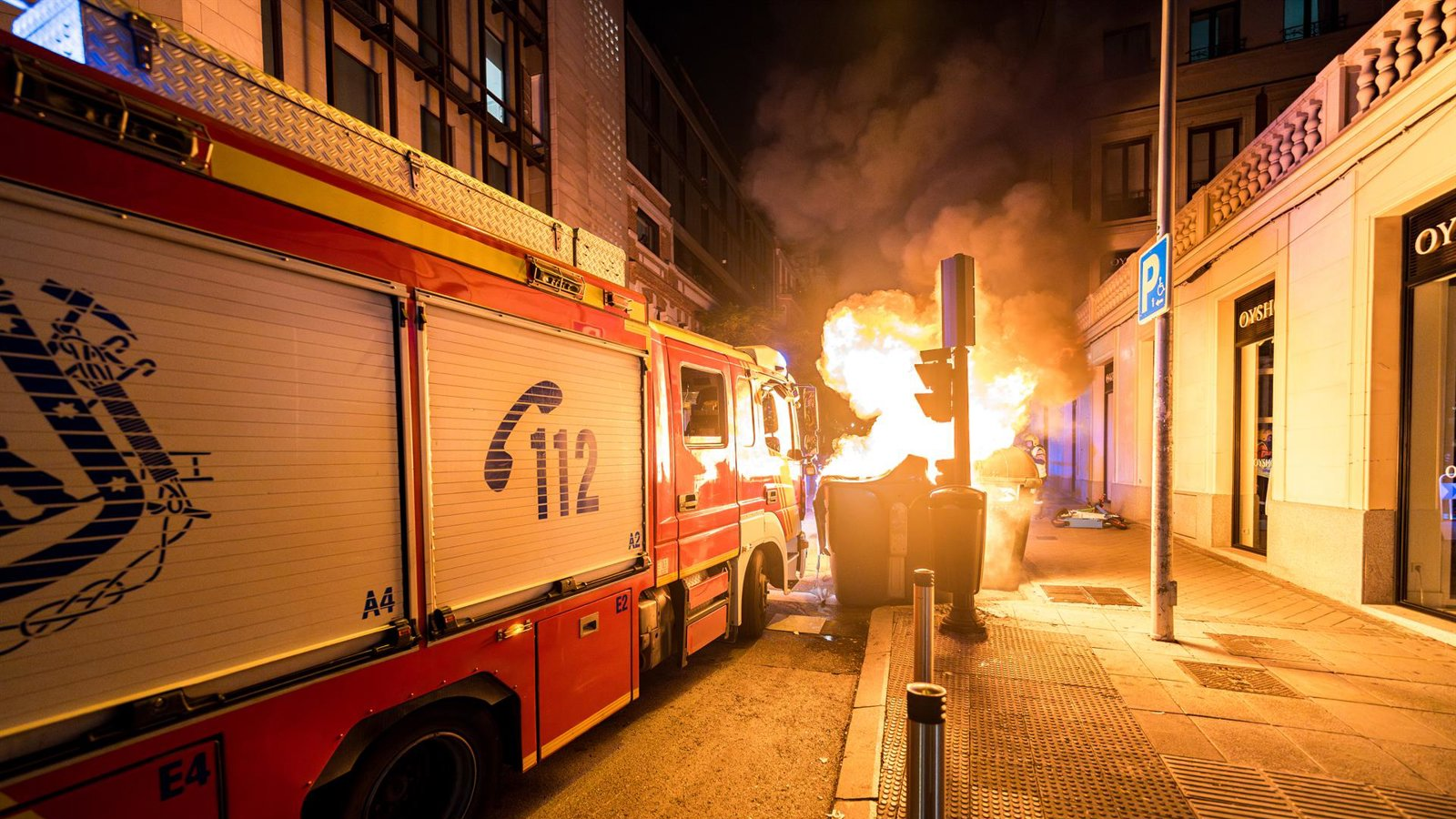 Investigan un incendio intencionado en Puente de Vallecas que calcina tres contenedores y daña dos coches