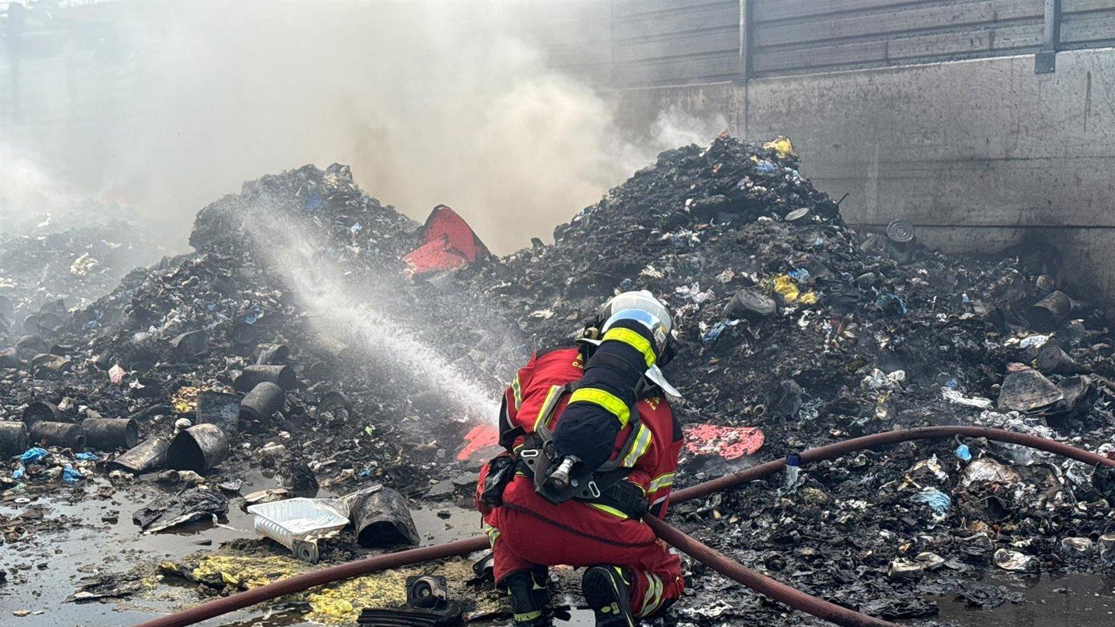 Bomberos trabajan en la extinción de un incendio en el exterior de una nave de reciclaje en Loeches